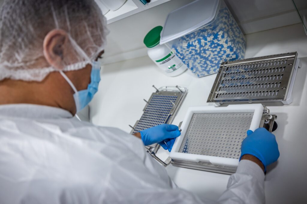 CarePlus pharmacist in protective gear preparing compounded capsules in the compounding lab